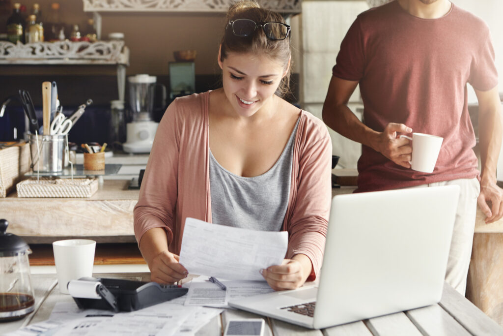 young pretty woman wearing glasses her head smiling happily while reading document saying that bank approved their mortgage application